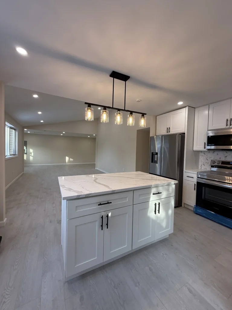 White kitchen with an island and pendant lighting from the Dream Space website
